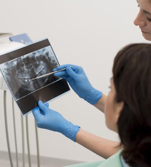 female-patient-looking-radiography-her-teeth-with-dentist